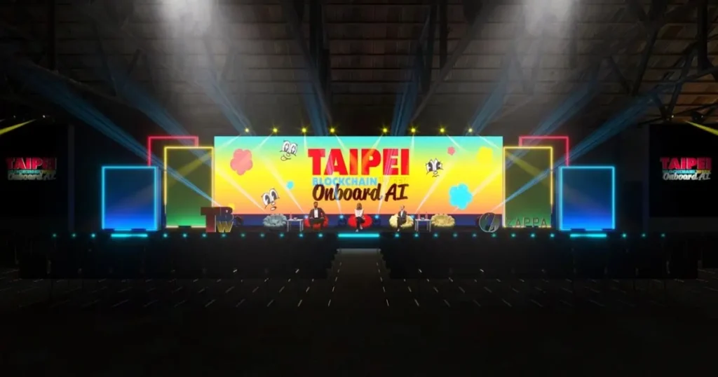 TBW2025 main stage setup at Songshan Cultural Park featuring colorful 'Taipei Blockchain Week Onboard AI' backdrop with BABY BLO$$OMS mascots, blue lighting, and multiple screens in warehouse venue.